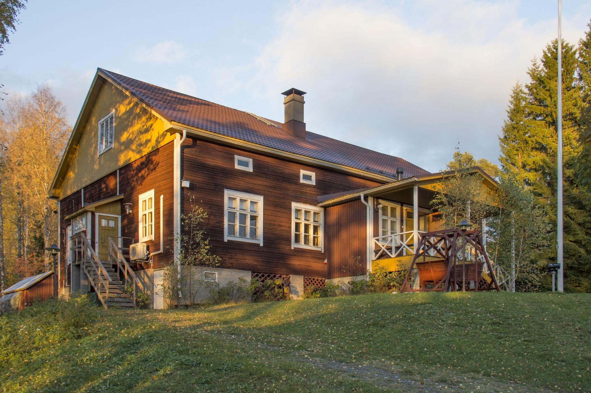 Puinen kaksikerroksinen talo ilta-auringossa
